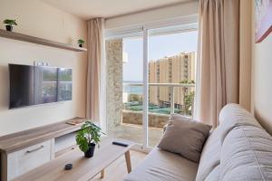 a living room with a couch and a large window at Apartamento HAPPY DAYS- Diana 1 in Benalmádena