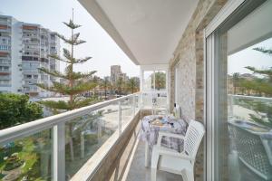 a balcony with a table and chairs and a view of the city at Apartamento HAPPY DAYS- Diana 1 in Benalmádena
