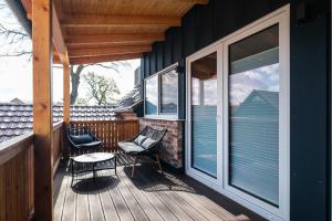 a porch with two chairs and a table on a house at Südseequartier in Elsterheide