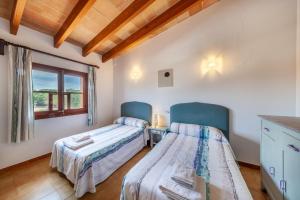 two twin beds in a room with a window at Villa Antonia in El Port
