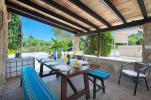 a wooden table and chairs on a patio at Villa Antonia in El Port