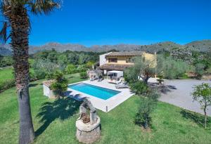 a house with a swimming pool and a palm tree at Villa Antonia in El Port