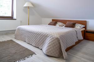 a bedroom with a bed with a white comforter at Penzion Tonička in Bulhary