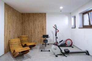 a room with a gym with a treadmill and chairs at Penzion Tonička in Bulhary