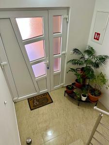 a hallway with potted plants and a glass door at Sweet Dreams Home in Korenica