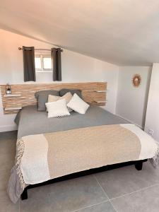 um quarto com uma cama grande e 2 almofadas em Sérénité - Superbe Terrasse et Jacuzzi ! em Canet-en-Roussillon