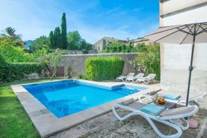 a swimming pool in a yard with an umbrella at Son March Petite in Pollença