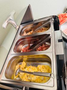 three trays of food on top of a stove at Vattengrändens Vandrarhem & Hotel in Norrköping