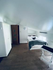 a white bedroom with a bed and a desk at Noclegi Przystanek Bieszczady w Centrum in Ustrzyki Dolne