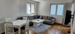 ein Wohnzimmer mit einem Sofa und einem Tisch in der Unterkunft Brand New Two Bedroom and One Living Room Apartment in a Great Location! in Sarajevo
