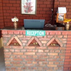 a brick counter with a laptop on top of it at Andes House in Kathmandu