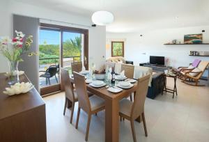 a dining room and living room with a table and chairs at Ses Crestes in Portocolom