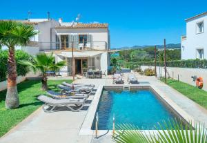 a villa with a swimming pool and lounge chairs at Ses Crestes in Portocolom