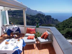 a balcony with tables and chairs and a view of the mountains at L'Arabesco B&B in Amalfi