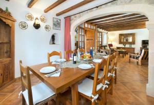 a dining room with a wooden table and chairs at Can Reus by Vintage Travel in Pollença