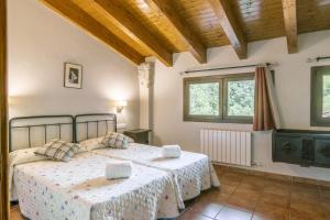 Un dormitorio con dos camas y dos ventanas. en Mossen Batista Faig, en Les Iglésies