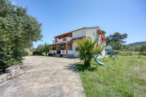 a house with a playground in front of it at Seaview Apartments in Pasman - Happy Rentals in Pašman