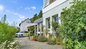 une maison blanche avec une voiture garée devant elle dans l'établissement Ferienwohnung zum Goldenen Kopf, à Elzach