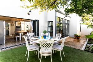 a patio with a table and chairs on a lawn at Serendipity in Hermanus
