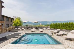 una piscina con sedie a sdraio e un piscina con piscina di Linta Hotel Wellness & Spa ad Asiago