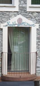uma varanda com uma janela com uma flor em La Noix - Alloggi ad uso turistico - VDA - ARVIER - n 0041 e n 0042 em Arvier