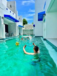 a man swimming in a swimming pool with a ball at Mona Lisa pool villa in Pattaya South