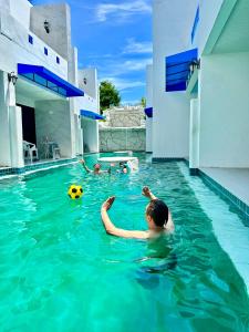 un hombre nadando en una piscina con una pelota en Mona Lisa pool villa, en Pattaya South
