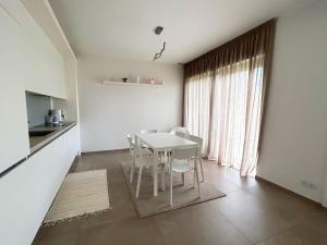 eine weiße Küche mit einem Tisch und Stühlen im Zimmer in der Unterkunft Ivory House in Jūrmala