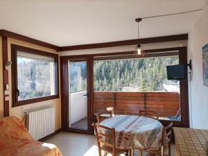 a living room with a table and a large window at Studio Pra-Loup, 1 pièce, 6 personnes - FR-1-165A-74 in Uvernet