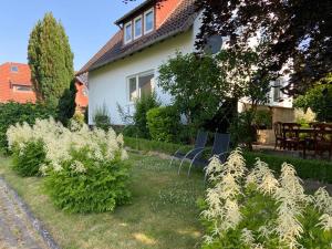 una casa con un montón de plantas en el patio en Haus Sunshine - Ferienwohnung Sunshine 1, en Hessisch Oldendorf