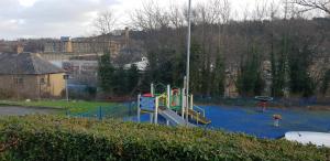 a playground with a slide in a park at Joyful Place in Huddersfield