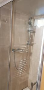a shower with a glass door in a bathroom at Joyful Place in Huddersfield