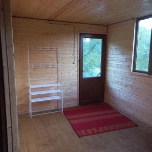 a room with a door and a shelf and a window at cottage dzama 