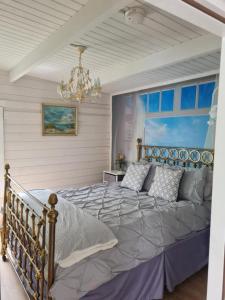 1 dormitorio con 1 cama grande y lámpara de araña en Bespoke Log Cabin en Littlehampton