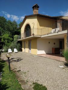 Una casa grande con balcón y entrada de grava. en Sunset Hill - Tuscany - Villa & private Pool, en Castelfiorentino