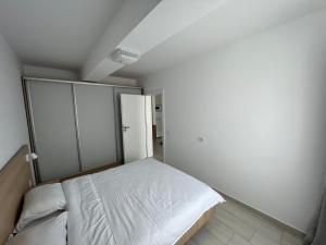 a white bedroom with a bed and a closet at Cristea Residence in Oradea