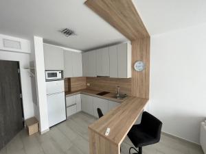 a kitchen with a wooden table and a desk at Cristea Residence in Oradea