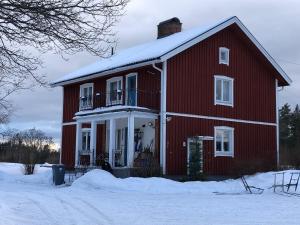una casa rossa con la neve sopra di Blåsbocka, lägenhet i hus 3 rok a Våmhus