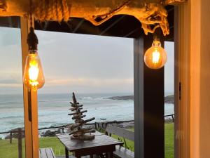 a room with a table and a view of the ocean at Mazeppa Sunrise Beach Accommodation in Mazeppa Bay