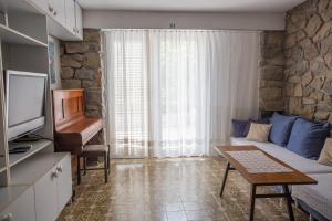 - un petit salon avec un canapé et une télévision dans l'établissement Stellar Suite, à Rab