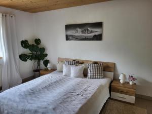 sypialnia z dużym łóżkiem z białą pościelą i poduszkami w obiekcie Bergbauernhof-Grinzens w mieście Grinzens