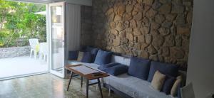 un salon avec un canapé et un mur en pierre dans l'établissement Stellar Suite, à Rab