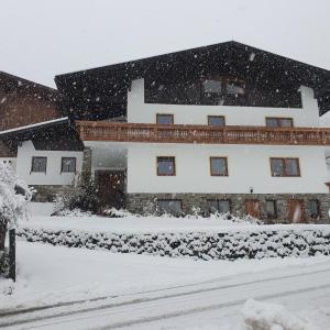 dom pokryty śniegiem na podwórku w obiekcie Bergbauernhof-Grinzens w mieście Grinzens