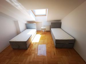 twee bedden in een kleine kamer met een raam bij Riviera Apartments in Niš
