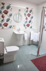 a bathroom with a toilet and a sink at Mere Brook House in Wirral