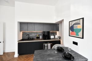 a kitchen with black cabinets and a table at Prestwick Green Pad in Prestwick