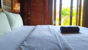 een wit bed in een kamer met een raam bij Morning Bali Bungalow in Canggu