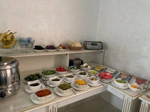 a shelf filled with bowls of food on a counter at Reikartz Amirun Tashkent in Tashkent