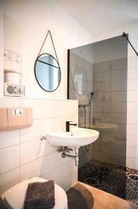 a bathroom with a sink and a toilet and a mirror at Moderne Wohnung in Ruhiger Umgebung nahe Messe in Berlin
