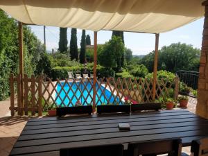 mesa de madera con sombrilla y piscina en Sunset Hill - Tuscany - Villa & private Pool, en Castelfiorentino